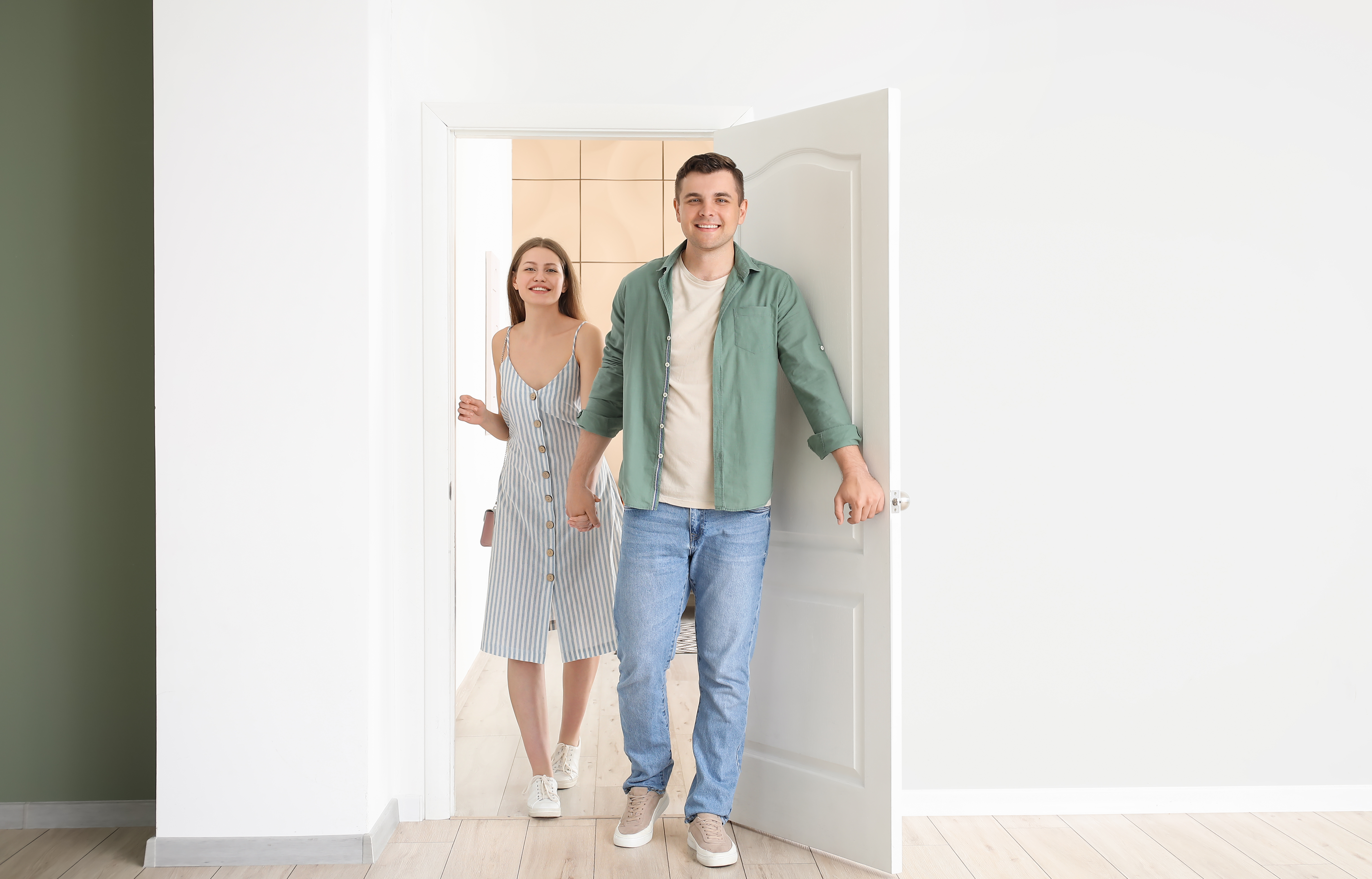 Happy couple opening door and enter the room | Source: Shutterstock.com